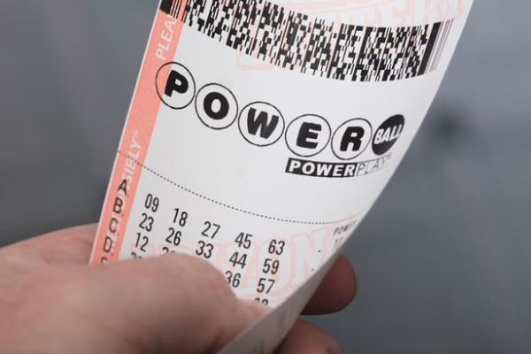 A photo of a man holding a Powerball lottery ticket in Kingman, Arizona.