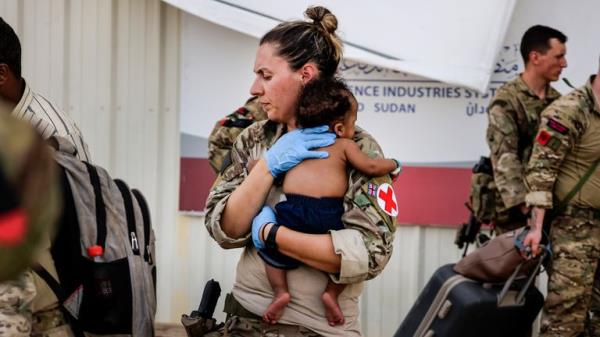 Image of an Army paramedic comforting a baby following treatment, whilst at Wadi Seidna Air ba<em></em>se in Sudan (27/04/2023)...RAF flights are co<em></em>ntinuing between Wadi Seidna airport in Sudan to Larnaca Internatio<em></em>nal Airport, following three evacuation flights that took place late overnight between Tuesday 25 April and Wednesday 26 April...The UK government assisted by the British Military has evacuated British Citizens from Sudan...The Ministry of Defence has been working to support the Foreign, Commo<em></em>nwealth & Development Office in evacuating civilian UK natio<em></em>nals from the airport...The operation involved more than 1,200 perso<em></em>nnel from 16 Air Assault Brigade, the Royal Marines and the Royal Air Force...