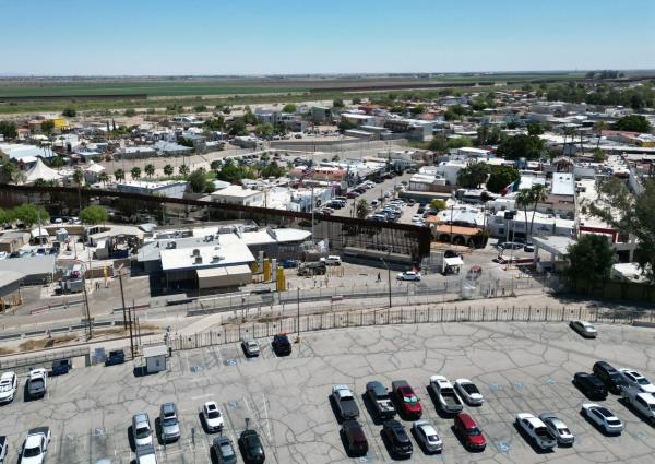 In this aerial photo, the border wall divides a parking lot in Andrade, California (lower half of photo), with the medical tourism town of Los Algodones, Mexico (top of photo).