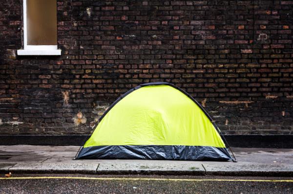 Homeless person sleeping in tent on city street