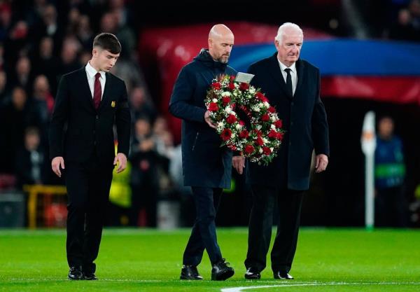 Manchester United manager Erik ten Hag (centre) lays a wreath in tribute to Bobby Charlton prior to the Champions League Group A match at Old Trafford, Manchester