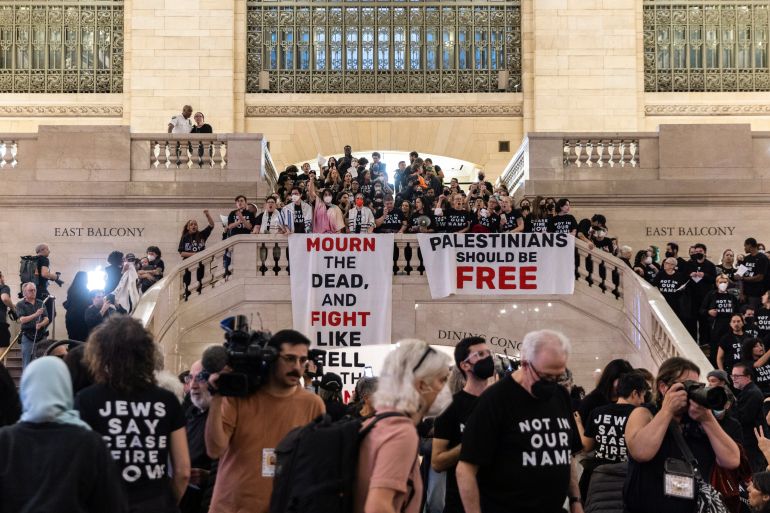 Protesters gathered on the co<em></em>ncourse of New York's Grand Central Station. They are wearing black and hanging a banner reading 'Palestinians must be free' from the top of the staircase