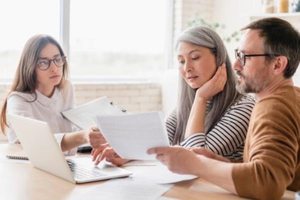 Co<em></em>nsultant financial advisor specialist dealing with mature couple clients, discuss health insurance, bank account history. Middle-aged family spouses customers co<em></em>nsult with relator broker.