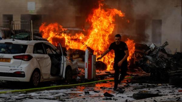 A man runs on a road as fire burns after rockets were launched from the Gaza Strip, in Ashkelon, Israel October 7, 2023. REUTERS/Amir Cohen</p>

<p>　　