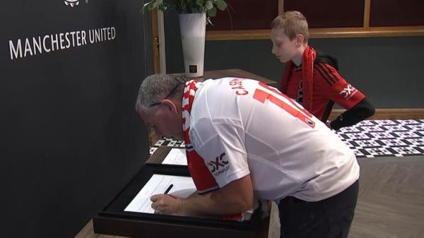 Fans sign a book of co<em></em>ndolence for Sir Bobby Charlton