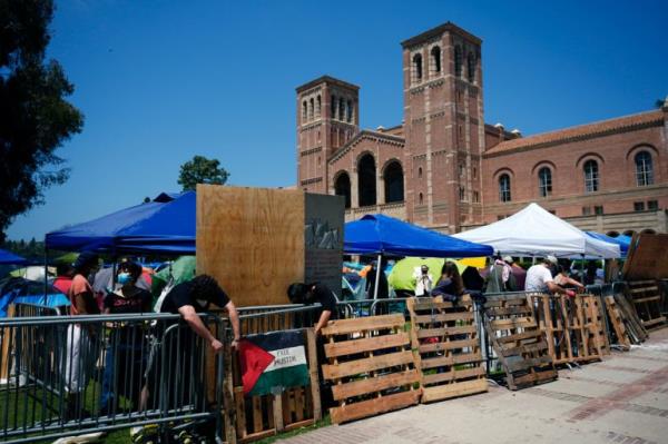 Pro-Palestine demo<em></em>nstrators restore a protective barricade at UCLA