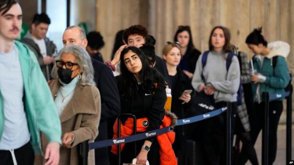 FILE - Travelers wait in line to board an Amtrak train ahead of the Thanksgiving Day holiday at 30th Street Station in Philadelphia, Nov. 23, 2022. 