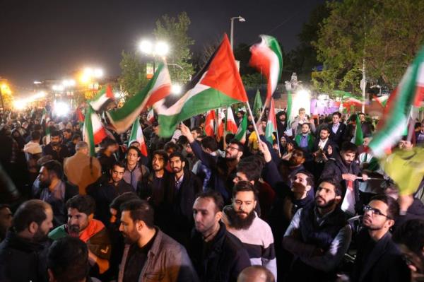 a protest at night with palestinian flags