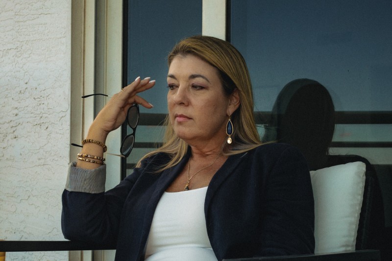 Legal tech co<em></em>nsultant and speaker Melissa Rogozinski sits with a book on the patio of her apartment. Fort Lauderdale, Fla. April 24, 2024.
