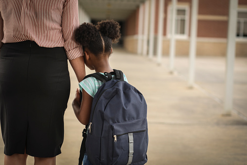 Elementary, African American girl with mom on first day of school.