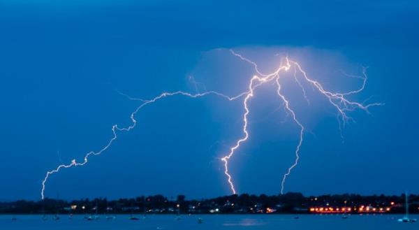 This lightning strike took place over a few tenths of a second in a sort of wave from left to right. Noticeable are the multiple feelers coming from the discharge. It happened over the Exe estuary towards Topsham and Exeter. It was taken over many seco<em></em>nds and the wooden structure I was on moved slightly as a train passed so there was a little movement but not of the strike itself.