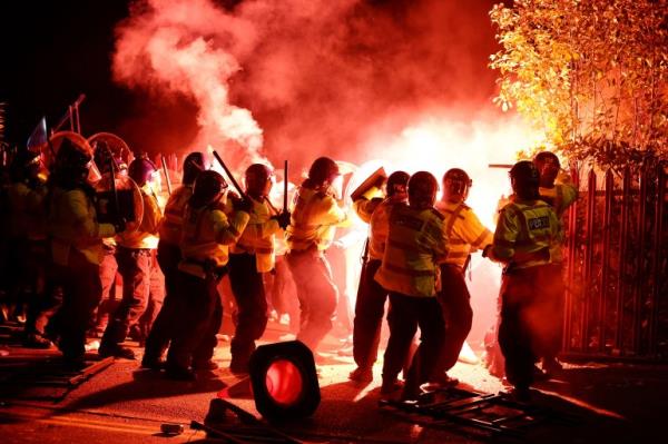 Legia Warsaw fans let off flares as they clash with police officers