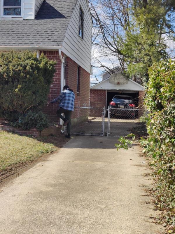 Denton Gayle on his phone in front of the home he is squatting in.