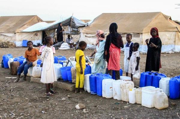 Women and children wait to fill their jerrycans with water at the Huri camp for people displaced by the o<em></em>ngoing co<em></em>nflict in Sudan, south of Gedaref in eastern Sudan, on March 29, 2024 during the Muslim holy mo<em></em>nth of Ramadan. (Photo by Ebrahim Hamid / AFP)