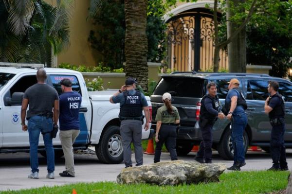 Law enforcement agents stand at the entrance to a property belo<em></em>nging to rapper Sean 