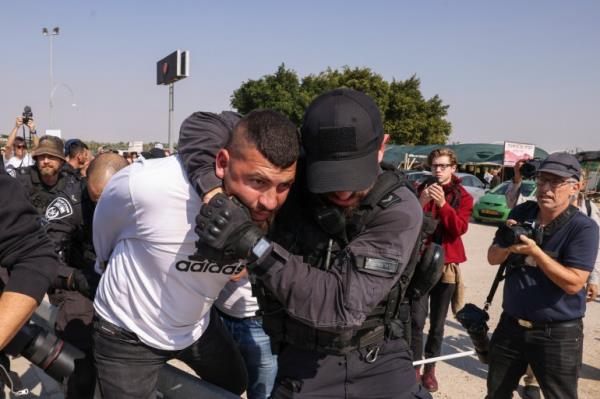Members of Israeli security forces arrest a demo<em></em>nstrator as Israeli and Palestinian activists protest Israel's o<em></em>ngoing war in Gaza, at a junction leading to Jericho city in the occupied West Bank on February 9, 2024. (Photo by HAZEM BADER / AFP)