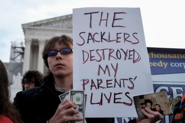A young man holds a sign outside of the Supreme Court. 