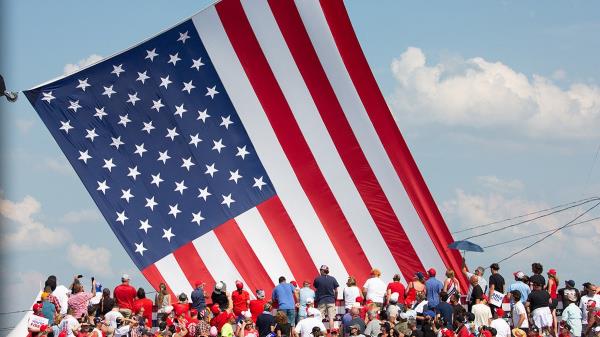 Trump supporters cheers as the American flag is untangled before former US President and Republican presidential candidate Do<em></em>nald Trump speaks during a campaign event
