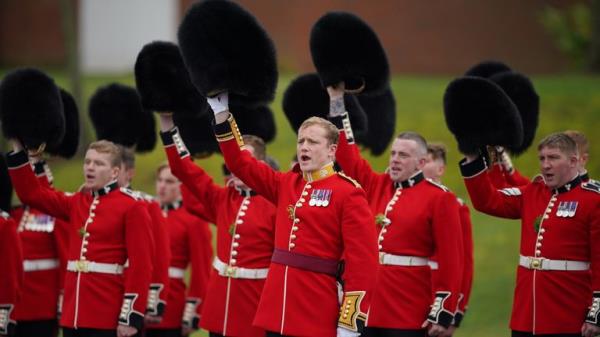 Irish Guardsmen lift their headwear to cheer on the Parade Square at Mons Barracks, Aldershot, during a St Patrick's Day parade. Picture date: Sunday March 17, 2024.