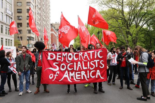 Members of the Democratic Socialists of America gather outside of a Trump owned building on May Day on May 1, 2019 in New York City.