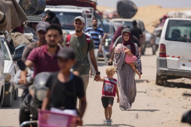 Displaced Palestinians walk flee from Khan Younis.