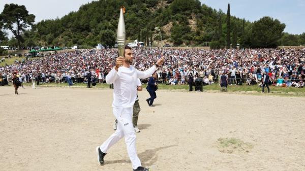 Ms Mina lights the flame. Pic: Reuters