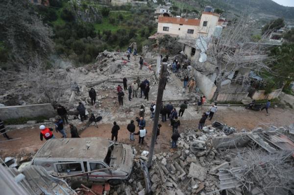 People gather on the rubble of a paramedic center that was destroyed by an Israeli airstrike early Wednesday in Hebbariye village, south Lebanon, Wednesday, March 27, 2024. The Israeli airstrike on a paramedic center l<em></em>inked to a Lebanese Sunni Muslim group killed several people of its members. The strike was one of the deadliest single attacks since violence erupted along the Lebanon-Israel border more than five mo<em></em>nths ago. (AP Photo/Mohammed Zaatari)