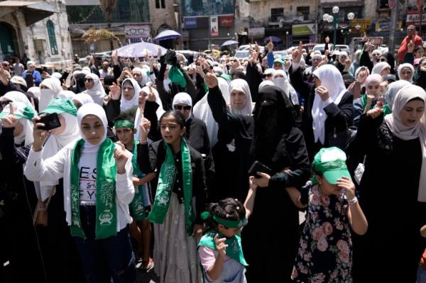 Palestinians wear Hamas militant group scarves and headbands as they protest the assassination of Hamas top leader Ismail Haniyeh, in the West Bank city of Nablus