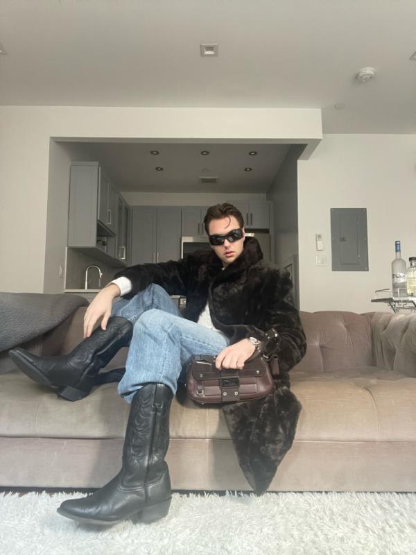 Hunter Shires, 25, in his $150 black leather cowboy boots he found at a vintage shop in Park Slope. With corporate office wardrobes feeling like the wild West in the post-pandemic, he says he wears them to work for comfort meets urban cowboy style.