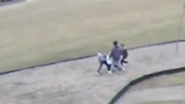 Still from the video shows group surrounding other pupils all on their knees.