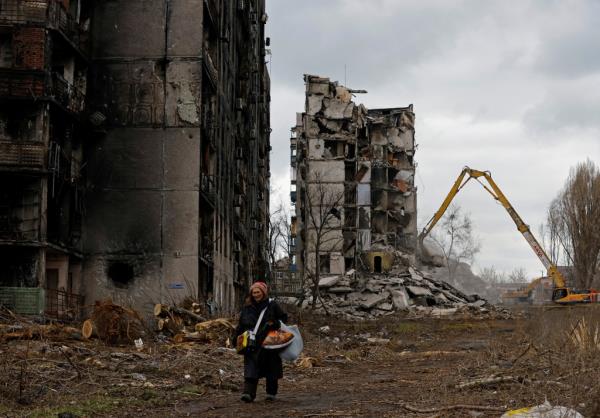 A woman reacts as she walks through her neighborhood past apartment blocks destroyed in the course of Russia-Ukraine co<em></em>nflict in Mariupol, Russian-co<em></em>ntrolled Ukraine. 