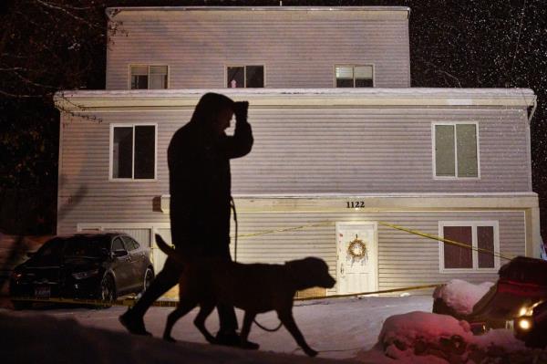 A man walks his dog past an off-campus