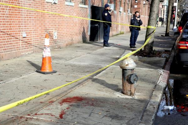 A blood stain on the sidewalk, at the taped-off scene of the New Year's Day stabbing.