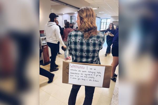 Wilmot wearing a sign in protest of the university closing of the diversity center.