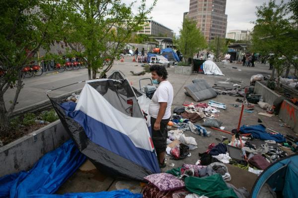 A man packs up his tent as the city of Los Angeles clears Toriumi Plaza in Little Tokyo wher<em></em>e a homeless encampment on Thursday, March 17, 2022 in Los Angeles, CA.