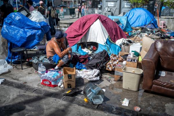 People at a homeless encampment in Toriumi Plaza at 1st St and Judge John Aiso St in Los Angeles Thursday, March 17, 2022.
