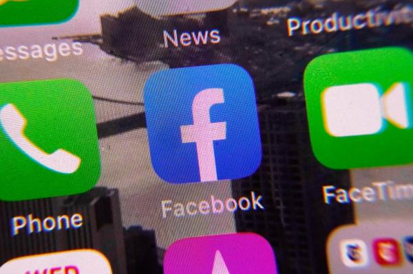 The Facebook app, center, is shown on a mobile phone screen, Wednesday, Jan. 25, 2023, in New York. Facebook parent me<em></em>ta is reinstating former President Do<em></em>nald Trump's perso<em></em>nal account after two-year suspension following the Jan. 6 insurrection, adding 