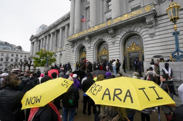 A crowd listens to speakers at a reparations rally outside of City Hall in San Francisco, Tuesday, March 14, 2023. 
