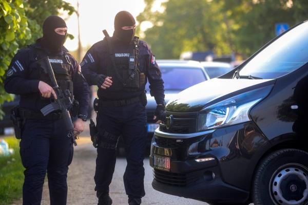Police officers block the street near the scene of a Thursday night attack in the village of Dubona, some 50 kilometers (30 miles) south of Belgrade, Serbia, Friday, May 5, 2023.