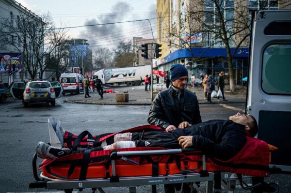 A man helps an injured civilian after Russian shelling to Ukrainian city of Kherson on December 24, 2022, wher<em></em>e five were killed and 20 injured.