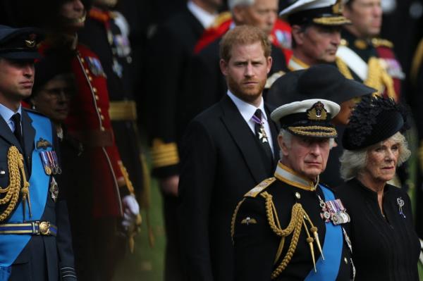 Britain's King Charles III (C), Britain's Camilla, Queen Consort, Britain's Prince William, Prince of Wales (L) and Britain's Prince Harry, Duke of Sussex (R) look at members of the Bearer Party transferring the coffin of Queen Elizabeth II, draped in the Royal Standard, form the State Gun Carriage of the Royal Navy into the State Hearse at Wellington Arch in Lo<em></em>ndon on September 19, 2022, after the State Funeral Service of Britain's Queen Elizabeth II.