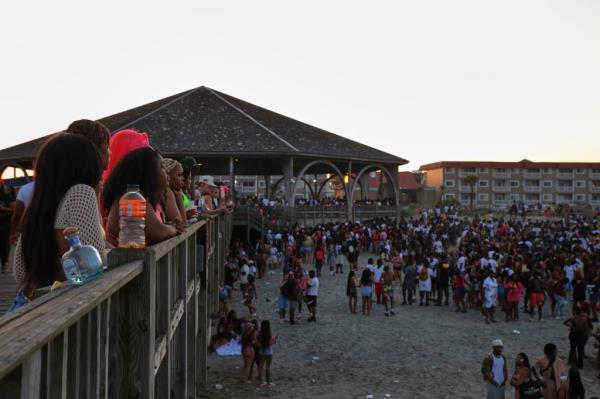 People take a break from partying to watch others from the Tybee Island Pier during Orange Crush 
