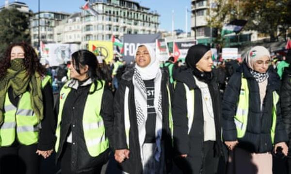 Five female protesters walking in a row.