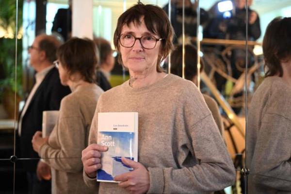 Laureate of the Prix Renaudot literary prize, French author Ann Scott poses with her book after the award ceremony in Paris on November 7, 2023.