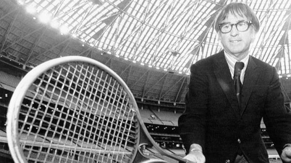 Bobby Riggs in suit wielding oversized racquet