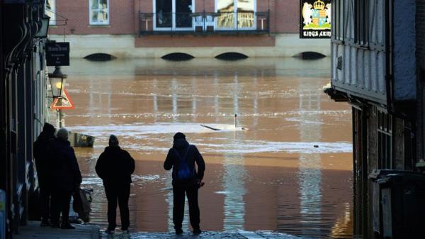 People stand and look at the rising water after the River Ouse burst its banks following heavy rain in York, Britain, December 11, 2023. REUTERS/Phil Noble TPX IMAGES OF THE DAY</p>

<p>　　