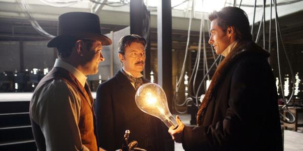 Hugh Jackman holds a lightbulb and speaks with David Bowie's Tesla in Christopher Nolan's The Prestige