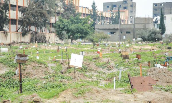  Placards indicate the names of the diseased at a makeshift cemetery, parts of which the Israeli army reportedly bulldozed to exhume bodies, in the al-Tuffah neighbourhood of Gaza City.—AFP 