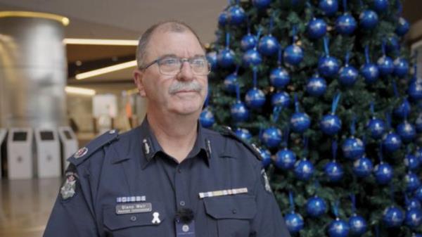 Road Policing Assistant Commissio<em></em>ner Glenn Weir stands before the Christmas tree with a bauble for each life lost on the state's roads for 2023. Supplied