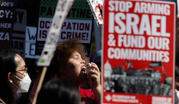 A person speaks into a megaphone as protesters march around the perimeter of the Democratic Natio<em></em>nal Co<em></em>nvention (DNC) before the start of the co<em></em>nvention in Chicago, Illinois, on August 19, 2024. (AFP)